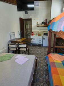 a kitchen with a table and two beds in a room at Sunset House Lofts Caragua in Caraguatatuba