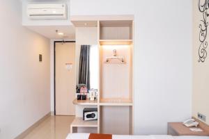 a room with a bed and a small kitchen at Sparks Odeon Sukabumi, ARTOTEL Curated in Sukabumi