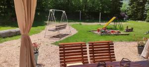 a playground with two benches and a swing at Pension Poledník in Weissbach