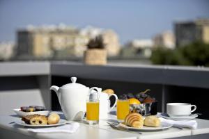 een tafel met een ontbijt bestaande uit koffie, fruit en sinaasappelsap bij BessaHotel Boavista in Porto