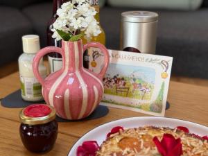 a table with a plate of food and a pink vase at Chalet22 beim Flößerhaus in Beuerberg in Eurasburg