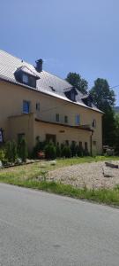 a house with a roof on the side of a road at Pension Poledník in Weissbach