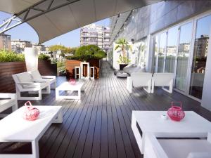 een balkon met witte tafels en stoelen op een gebouw bij BessaHotel Boavista in Porto