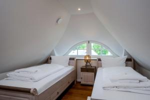 two beds in a room with a window at Jade 1 in Born