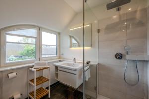 a white bathroom with a sink and a shower at Jade 1 in Born +20 photos
