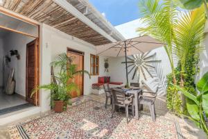 a patio with a table and chairs and an umbrella at Casa Moraira in Cartagena de Indias