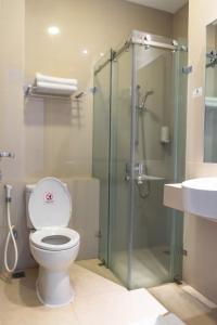 a bathroom with a toilet and a glass shower at Sparks Odeon Sukabumi, ARTOTEL Curated in Sukabumi +19 photos