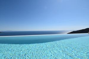 a pool of water with the ocean in the background at Apiron Luxury Villa in Agía Kyriakí
