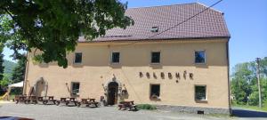 a building with benches in front of it at Pension Poledník in Weissbach +4 photos