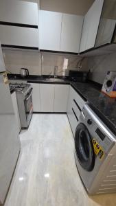 eine Küche mit Waschmaschine und Spüle in der Unterkunft Evrest in New cairo