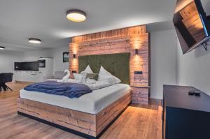 a bedroom with a large bed with a brick wall at Annies Bergwelt Haus Waldherz in Bodenmais