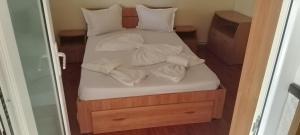 a bed with white sheets and pillows on it at Casa de vacanta in Eforie Nord