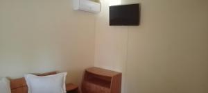 a room with a chair and a tv on the wall at Casa de vacanta in Eforie Nord