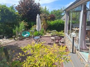 a patio with an umbrella and a table and chairs at Villa Cap Avalenn in Fouesnant +10 photos