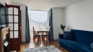 a living room with a couch and a table and a window at Reef Lodge in Newquay