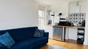 a living room with a blue couch and a kitchen at Reef Lodge in Newquay +82 photos