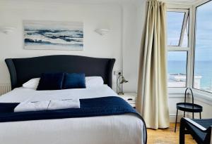 a bedroom with a bed and a window with the ocean at Reef Lodge in Newquay