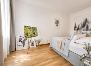 a white bedroom with a bed and a wooden floor at Schwarzwald Loft Baden-Baden in Baden-Baden
