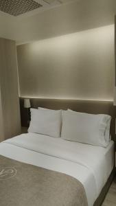 a large bed with white pillows in a room at VPV Suites & Casino in Medellín