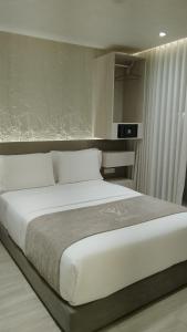 a bedroom with a large white bed in a room at VPV Suites & Casino in Medellín