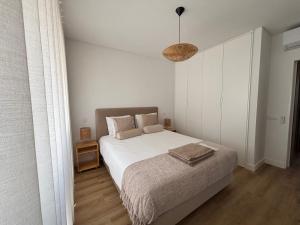 a bedroom with a bed and a pendant light at Vila apartment, free parking in Cascais