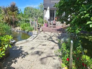a walkway leading to a house with a pond at Villa Cap Avalenn in Fouesnant