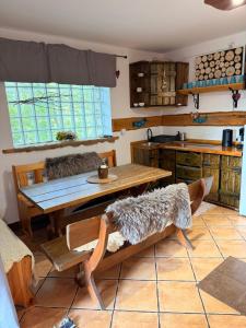 a kitchen with a wooden table and benches in a room at Uroczysko in Brenna