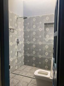 a bathroom with a toilet and a wall at Aali villas in Mararikulam +43 photos