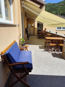a blue chair on a patio with tables and chairs at LA RIPA in Riomaggiore