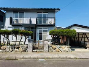 an apartment building with trees and rocks in front of it at Biwa Asahi 家族友人大人数ok BBQok in Takashima +6 photos