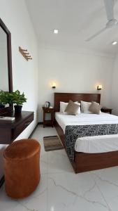 a hotel room with a bed and a chair at Induwara Villa in Ahungalla