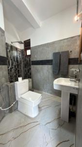 a bathroom with a white toilet and a sink at Induwara Villa in Ahungalla +24 photos