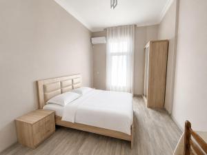 a white bedroom with a bed and a window at Guesthouse Tornike in Gonio