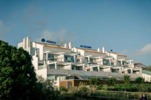 a large white apartment building on top of a hill at Pérola do Oceano in Manta Rota