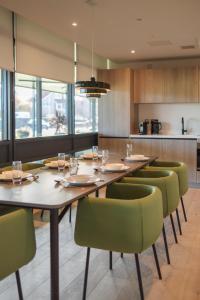 a dining room with wooden tables and green chairs at The SPACE To Stay Aparthotel in St. Andrews