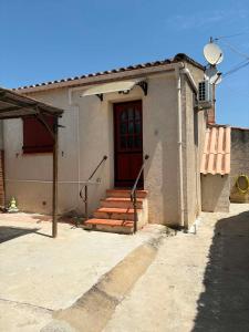 a small house with a red door and stairs at Mareva House - Discreet with parking in Gignac-la-Nerthe