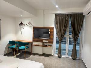 a hotel room with a desk and a television at Hotel Skyboat Inn in Nashik