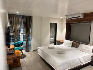 a bedroom with a large white bed and a desk at Hotel Skyboat Inn in Nashik +32 photos