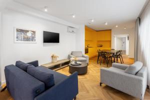 a living room with two blue couches and a table at Aparthotel Blend City Center in Bucharest