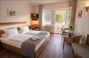 una camera da letto con un letto, un tavolo e una finestra di Hotel Schön am Rhein a Rüdesheim am Rhein