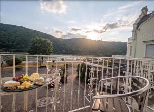 un balcone con un tavolo su cui è appoggiato del cibo di Hotel Schön am Rhein a Rüdesheim am Rhein