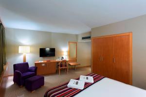ein Hotelzimmer mit einem Bett, einem Stuhl und einem Schreibtisch in der Unterkunft Kent Hotel in Bursa