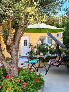 a woman sitting in a chair under an umbrella at Apartmani Klarić in Zadar