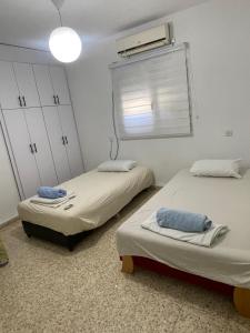 a room with two beds and a window with aperature at דירה בעמק in Bet Sheʼan +1 photo