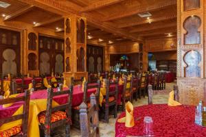 a dining room with red and yellow tables and chairs at Kasbah Hotel Tombouctou in Merzouga +243 photos
