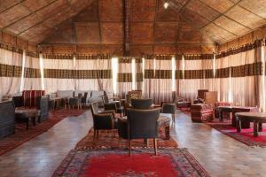 a large room with chairs and tables and curtains at Kasbah Hotel Tombouctou in Merzouga