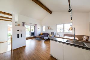 an open kitchen and living room with white cabinets at Ferienwohnungen Mountainfloor - Chiemgau Karte in Inzell