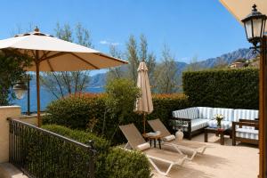 a patio with an umbrella and chairs and a table at Kotor Bay Villas by Huma in Dobrota