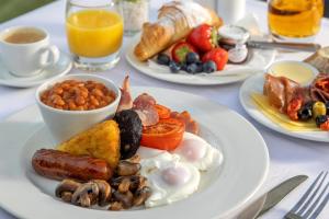 ein Tisch mit Tellern mit Frühstücksspeisen in der Unterkunft Best Western Claydon Hotel in Ipswich