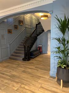 a hallway with a staircase and a potted plant at Best Western Moores Central Hotel in St. Peter Port +67 photos